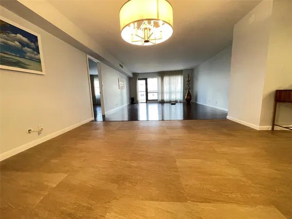 a view of a room with a hanging light and gym equipment