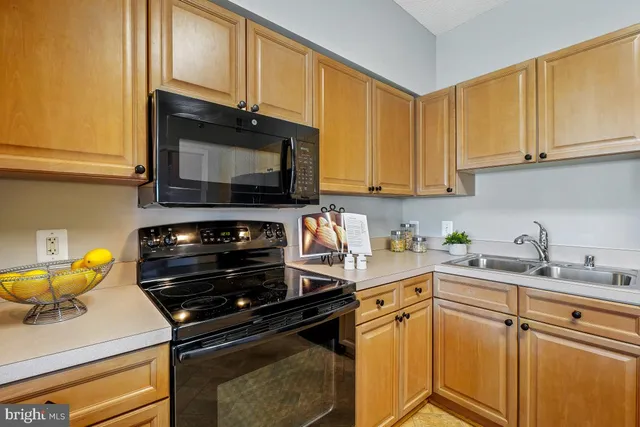 a kitchen with stainless steel appliances a stove a sink dishwasher and cabinets with wooden floor