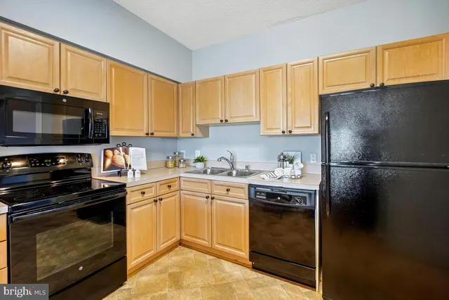 a kitchen with a sink stainless steel appliances and cabinets