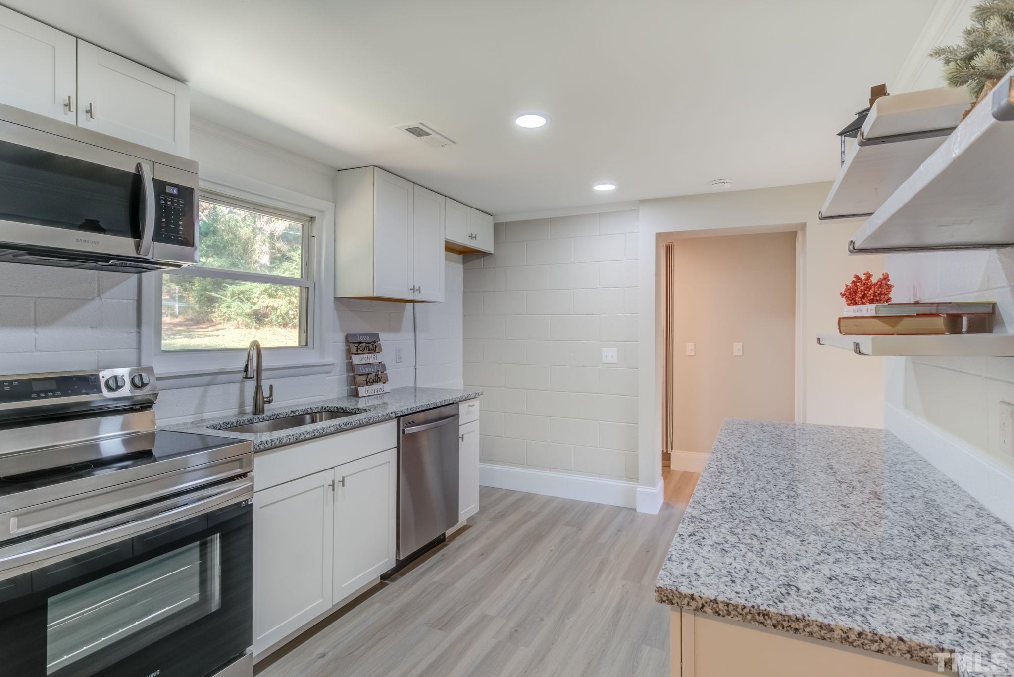 9800 Fanny Brown Road Raleigh, NC 27603 - Photo 4 of 29 a kitchen with stainless steel appliances granite countertop a sink stove and microwave