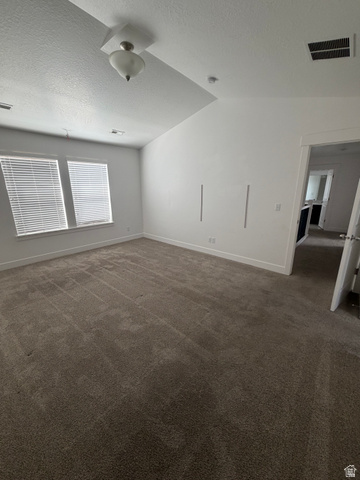 878 West Mckenna Road Bluffdale, UT 84065 - Photo 8 of 11 Carpeted flooring, vaulted ceiling, two windows with blinds, and white walls