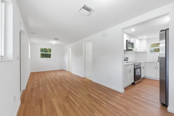 a kitchen with wooden floors and appliances