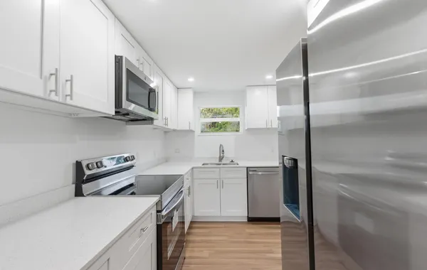 a kitchen with stainless steel appliances granite countertop a sink a stove and a refrigerator
