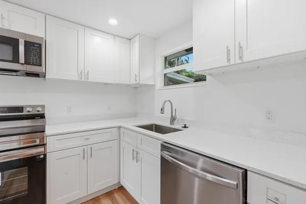 a kitchen with stainless steel appliances white cabinets and a sink