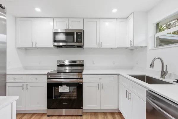 a kitchen with white cabinets and stainless steel appliances