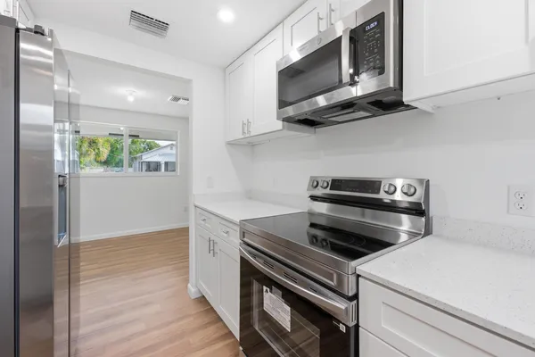 a kitchen with stainless steel appliances a stove microwave and sink