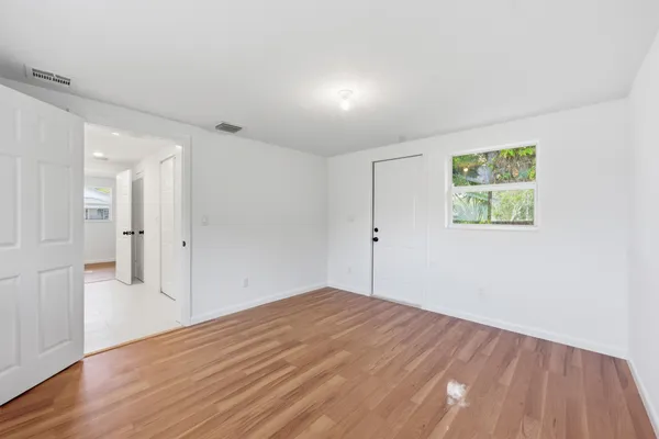 a view of empty room with wooden floor