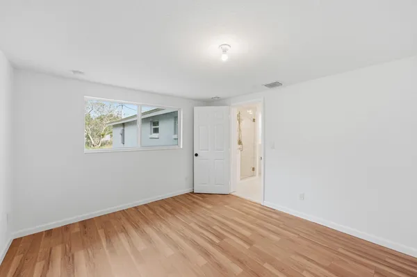 a view of empty room with wooden floor