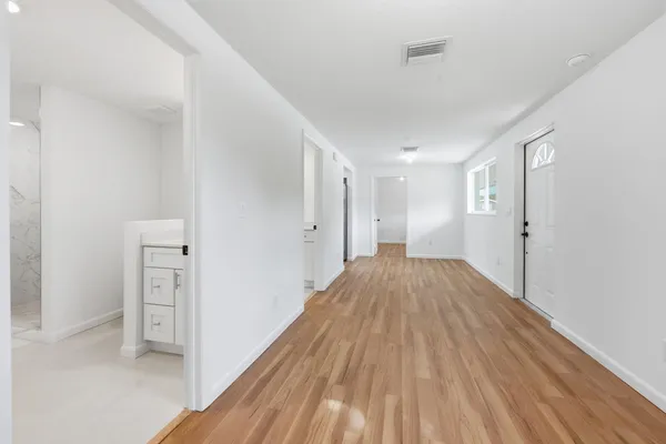 a view of a hallway with wooden floor and closet