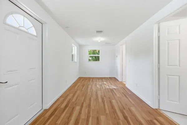 a view of empty room with wooden floor