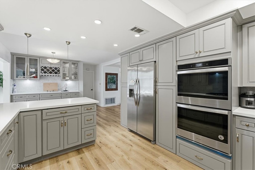 11413 Etiwanda Avenue Porter Ranch, CA 91326 - Photo 37 of 49 a kitchen with kitchen island granite countertop stainless steel appliances and wooden cabinets