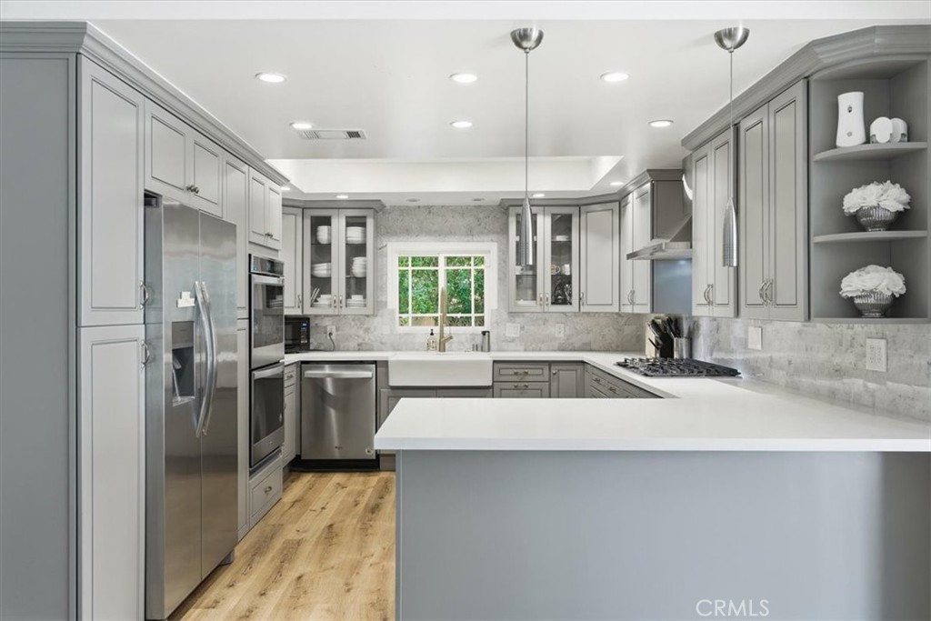 11413 Etiwanda Avenue Porter Ranch, CA 91326 - Photo 41 of 49 a kitchen with a sink stainless steel appliances and cabinets