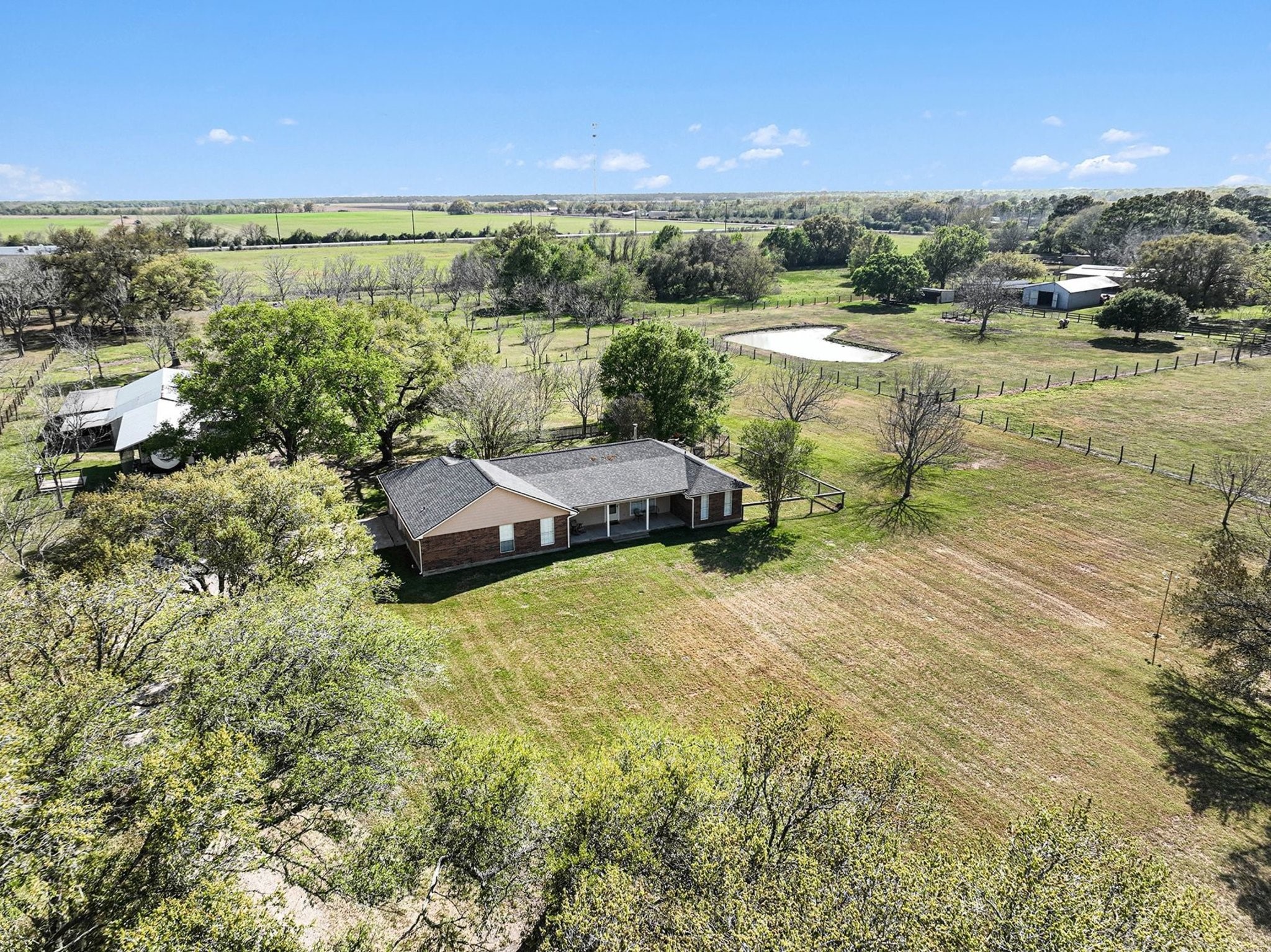 21503 Pecan Bend Road Damon, TX 77430 - Photo 5 of 45 a view of a lake with lawn chairs and large trees