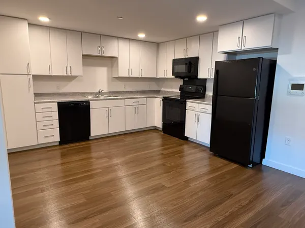 a kitchen with a refrigerator a stove top oven a sink and cabinets