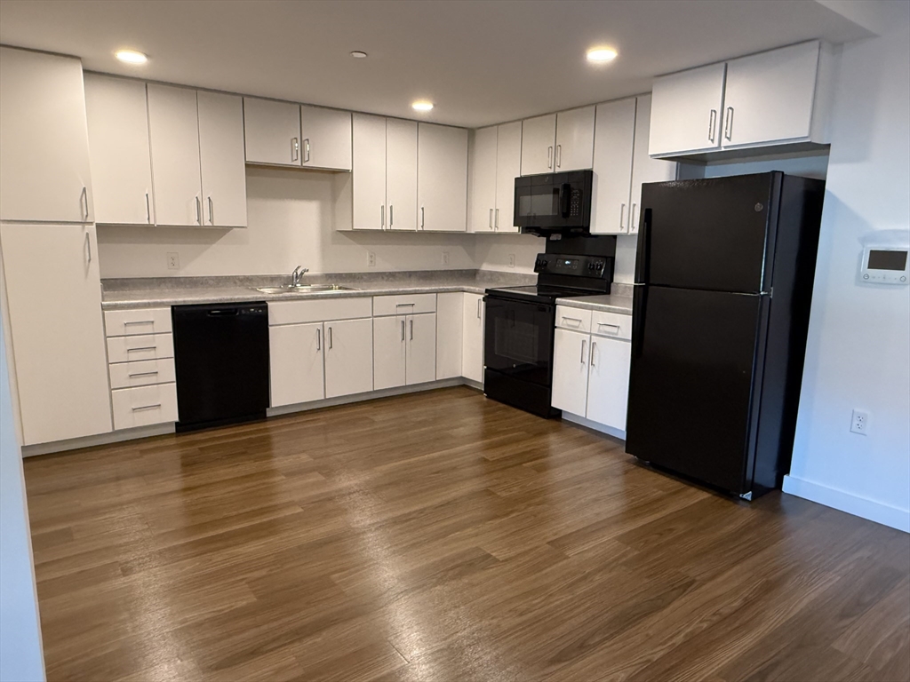 a kitchen with a refrigerator a stove top oven a sink and cabinets