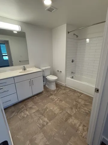 a bathroom with a granite countertop sink a toilet and shower