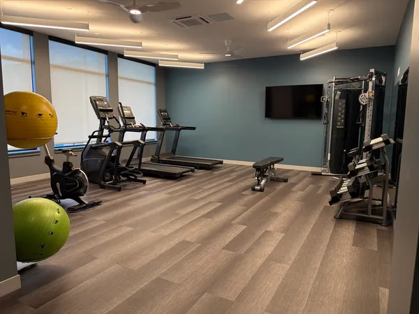 a room with gym equipment and a flat screen tv