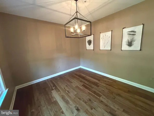 a view of a room with wooden floor and white walls