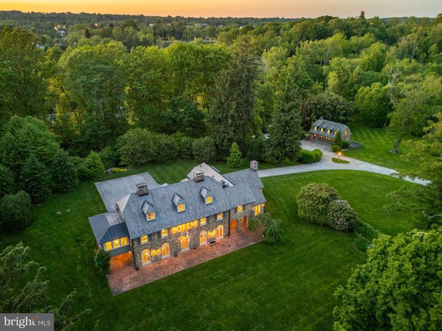 a view of a big house with a big yard and large trees