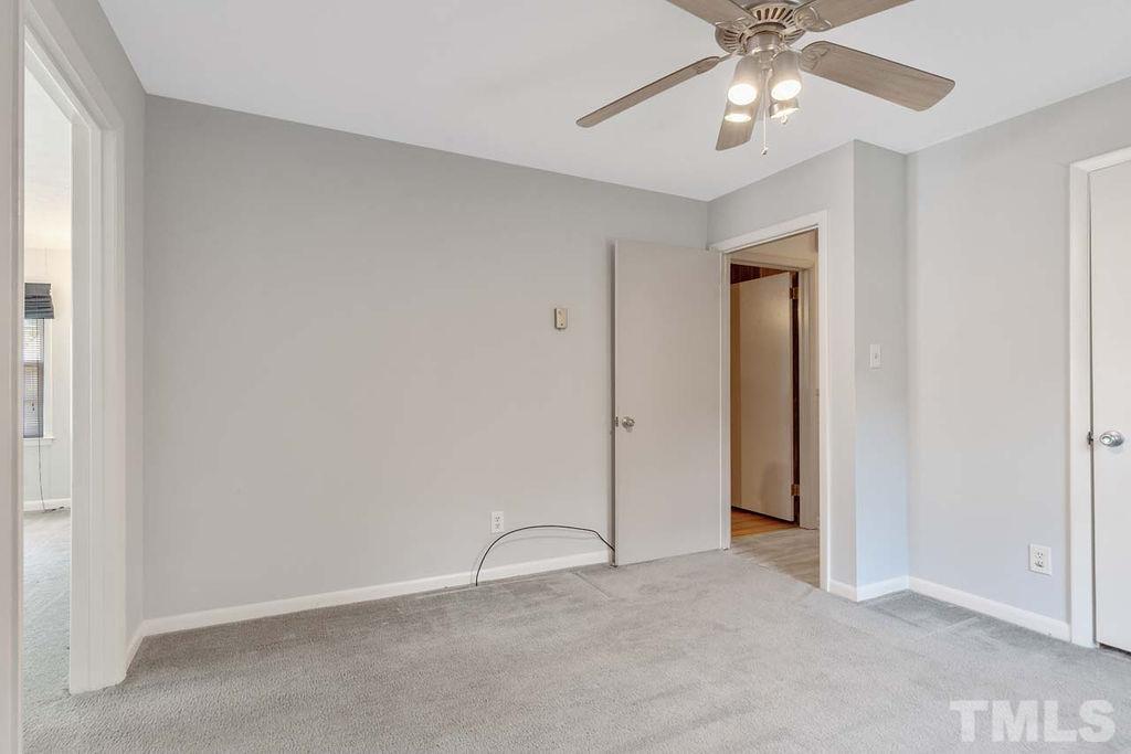 3806 Lee Road Raleigh, NC 27604 - Photo 18 of 33 an empty room with a chandelier fan and closet area