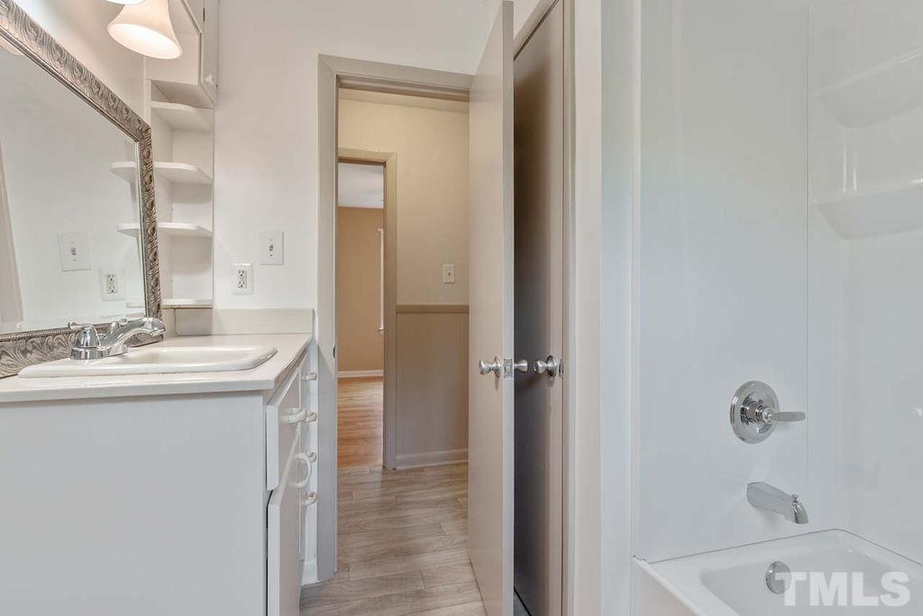 3806 Lee Road Raleigh, NC 27604 - Photo 24 of 33 a bathroom with a sink and mirror with bathtub