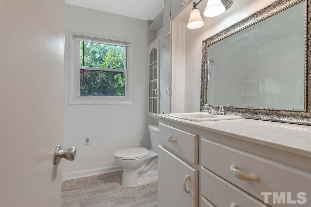 3806 Lee Road Raleigh, NC 27604 - Photo 25 of 33 a bathroom with a sink a toilet and a mirror