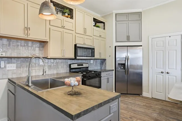 a kitchen with stainless steel appliances granite countertop a sink a stove and a refrigerator