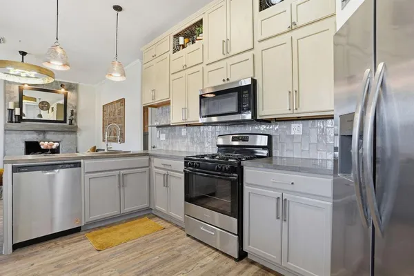 a kitchen with stainless steel appliances granite countertop a stove a sink and a refrigerator