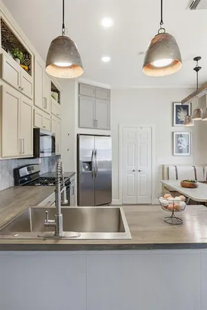 a kitchen with stainless steel appliances granite countertop a sink a refrigerator and a stove