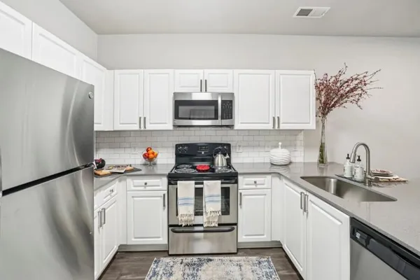a kitchen with stainless steel appliances a stove refrigerator sink and cabinets