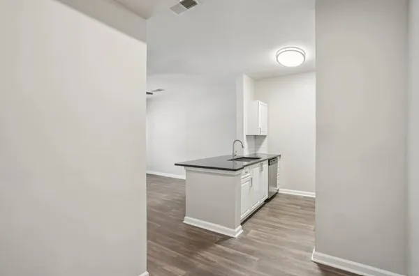 a living room with stainless steel appliances wooden floor and a window