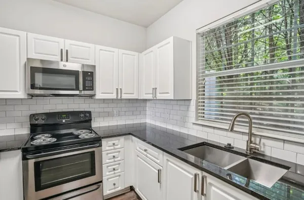 a kitchen with stainless steel appliances granite countertop a refrigerator and a sink