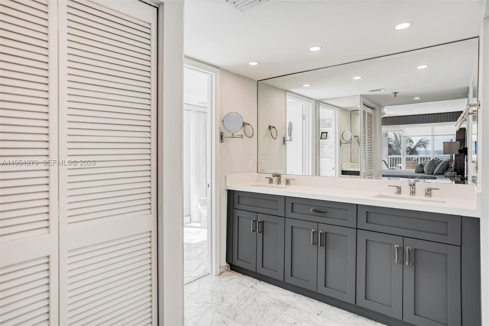 9341 Collins Avenue, Unit 201 Surfside, FL 33154 - Photo 15 of 34 a bathroom with a double vanity sink and a mirror