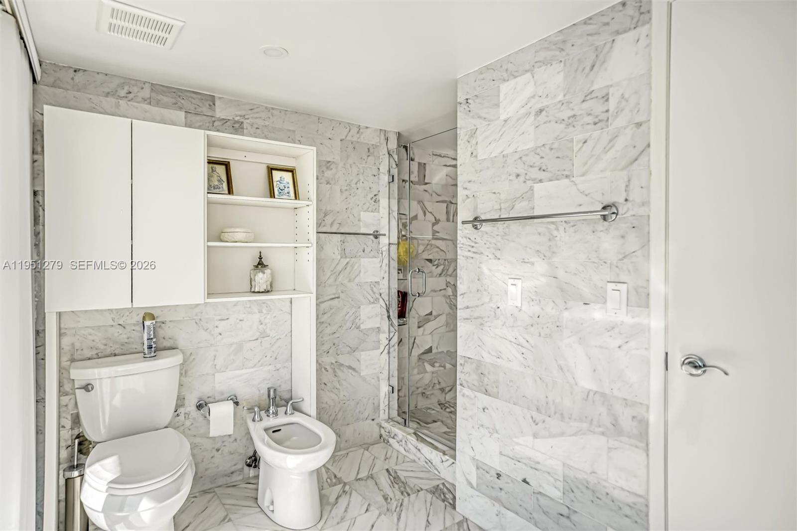 9341 Collins Avenue, Unit 201 Surfside, FL 33154 - Photo 17 of 34 a white toilet sitting next to a bathroom sink