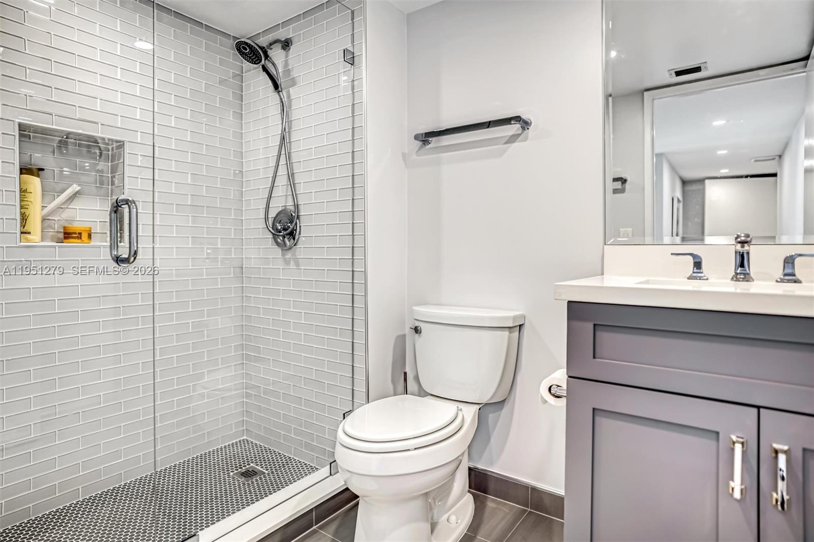 9341 Collins Avenue, Unit 201 Surfside, FL 33154 - Photo 20 of 34 a bathroom with a toilet sink vanity and shower