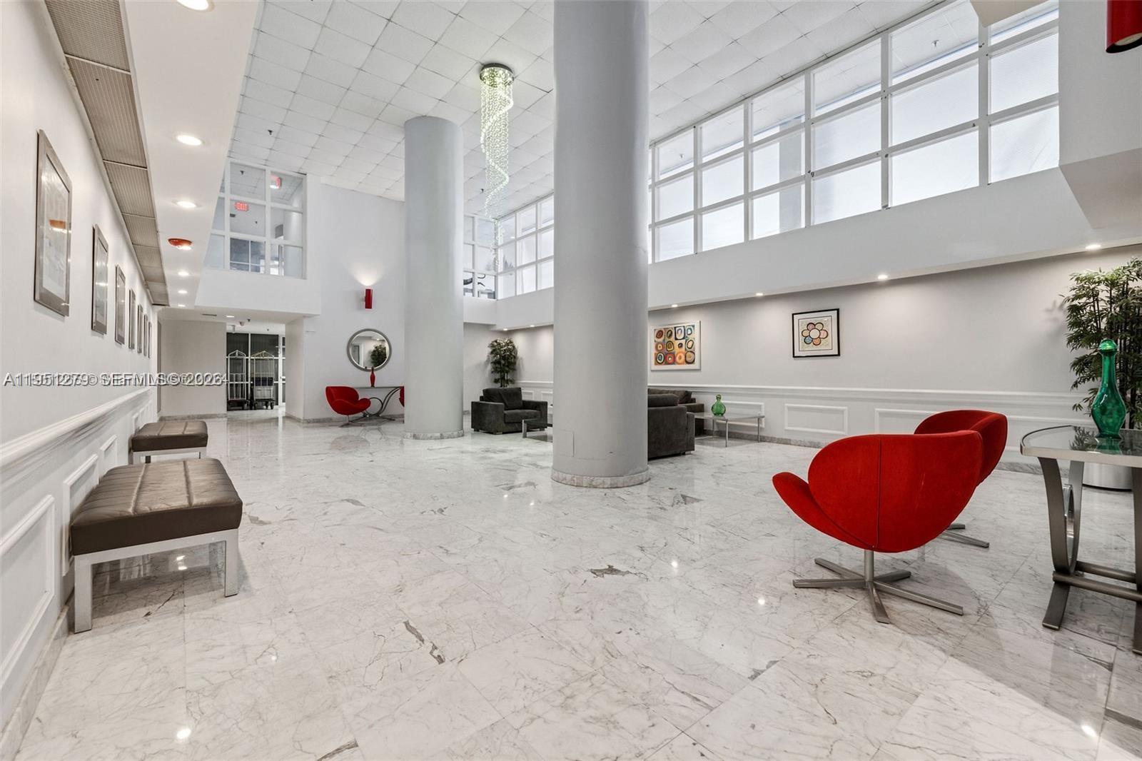 9341 Collins Avenue, Unit 201 Surfside, FL 33154 - Photo 28 of 34 a living room with furniture and a floor to ceiling window