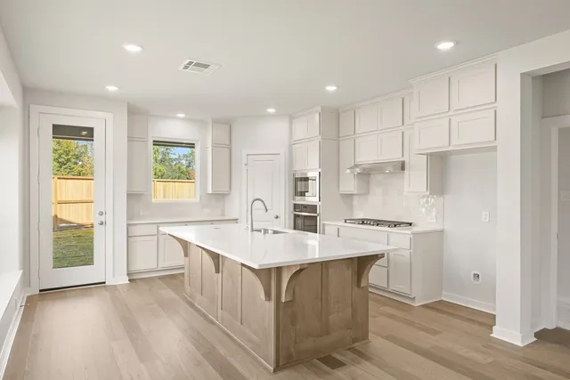 a kitchen with a sink a center island cabinets and a window
