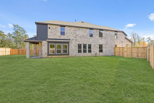 a view of a house with a big yard and large trees