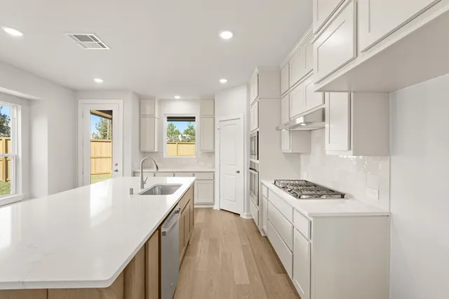 a kitchen with sink stove and refrigerator