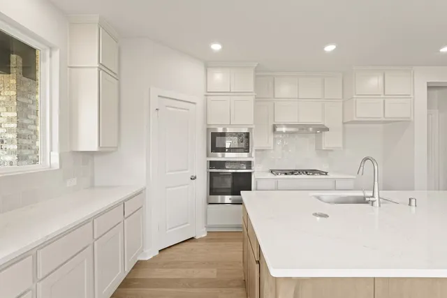 a kitchen with kitchen island a sink stainless steel appliances and cabinets