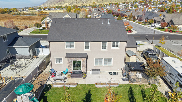 368 East 700 North Springville, UT 84663 - Photo 14 of 55 Rear view of house featuring a residential view, a fenced backyard, stone siding, a patio, and stucco siding