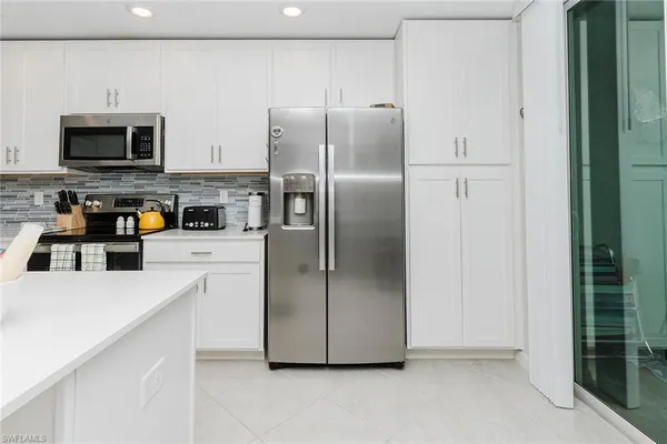 a kitchen with stainless steel appliances granite countertop a refrigerator a stove and a microwave