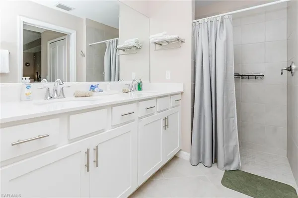 a bathroom with a double vanity sink and mirror