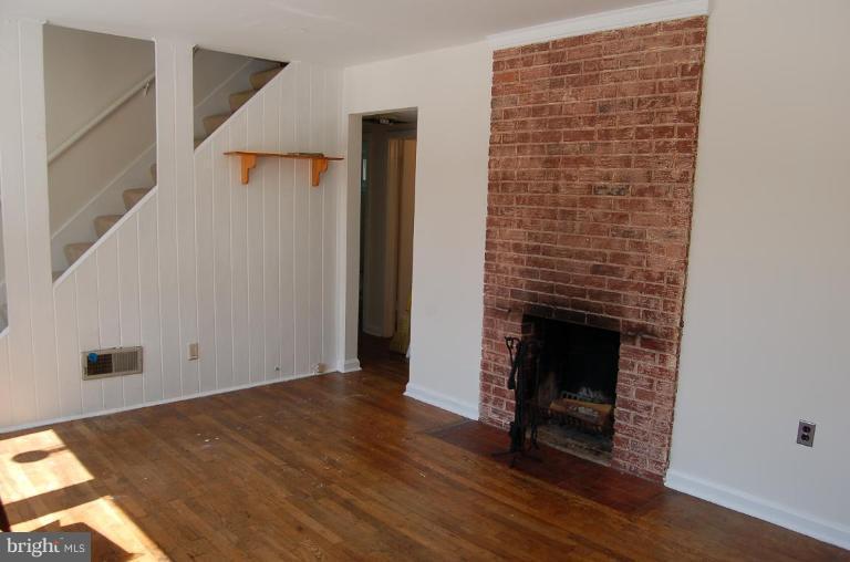 904 Robin Road Silver Spring, MD 20901 - Photo 3 of 10 a view of an empty room with wooden floor and a fireplace