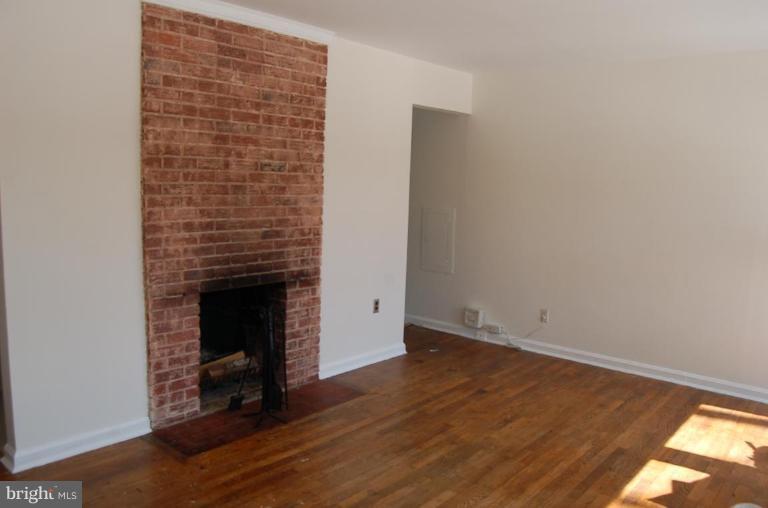 904 Robin Road Silver Spring, MD 20901 - Photo 4 of 10 a view of an empty room with wooden floor and a fireplace