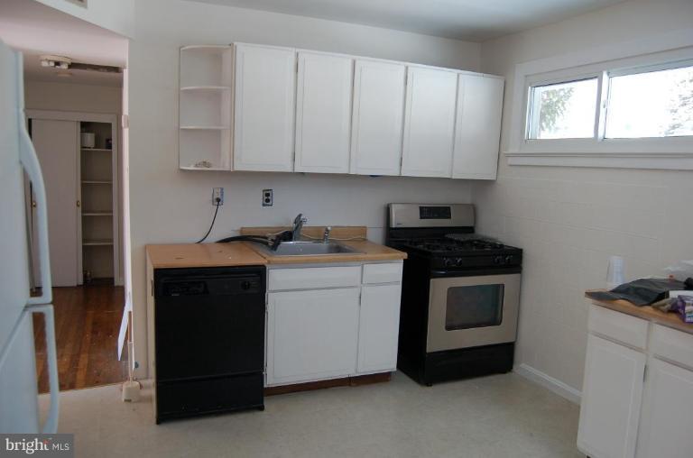 904 Robin Road Silver Spring, MD 20901 - Photo 5 of 10 a kitchen with stainless steel appliances granite countertop a stove a sink and a refrigerator