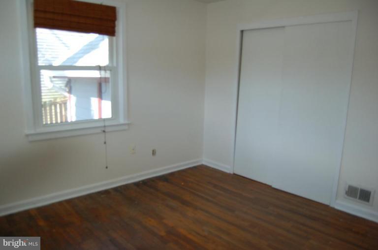 904 Robin Road Silver Spring, MD 20901 - Photo 7 of 10 an empty room with wooden floor and windows