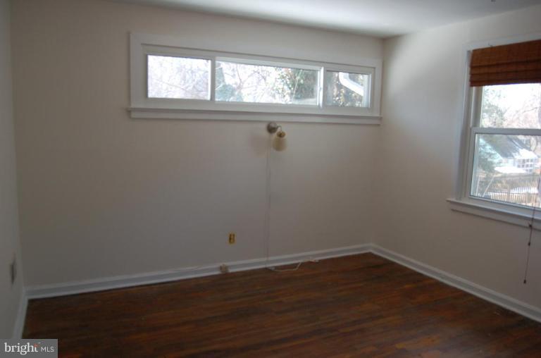 904 Robin Road Silver Spring, MD 20901 - Photo 8 of 10 a view of an empty room with wooden floor and a window
