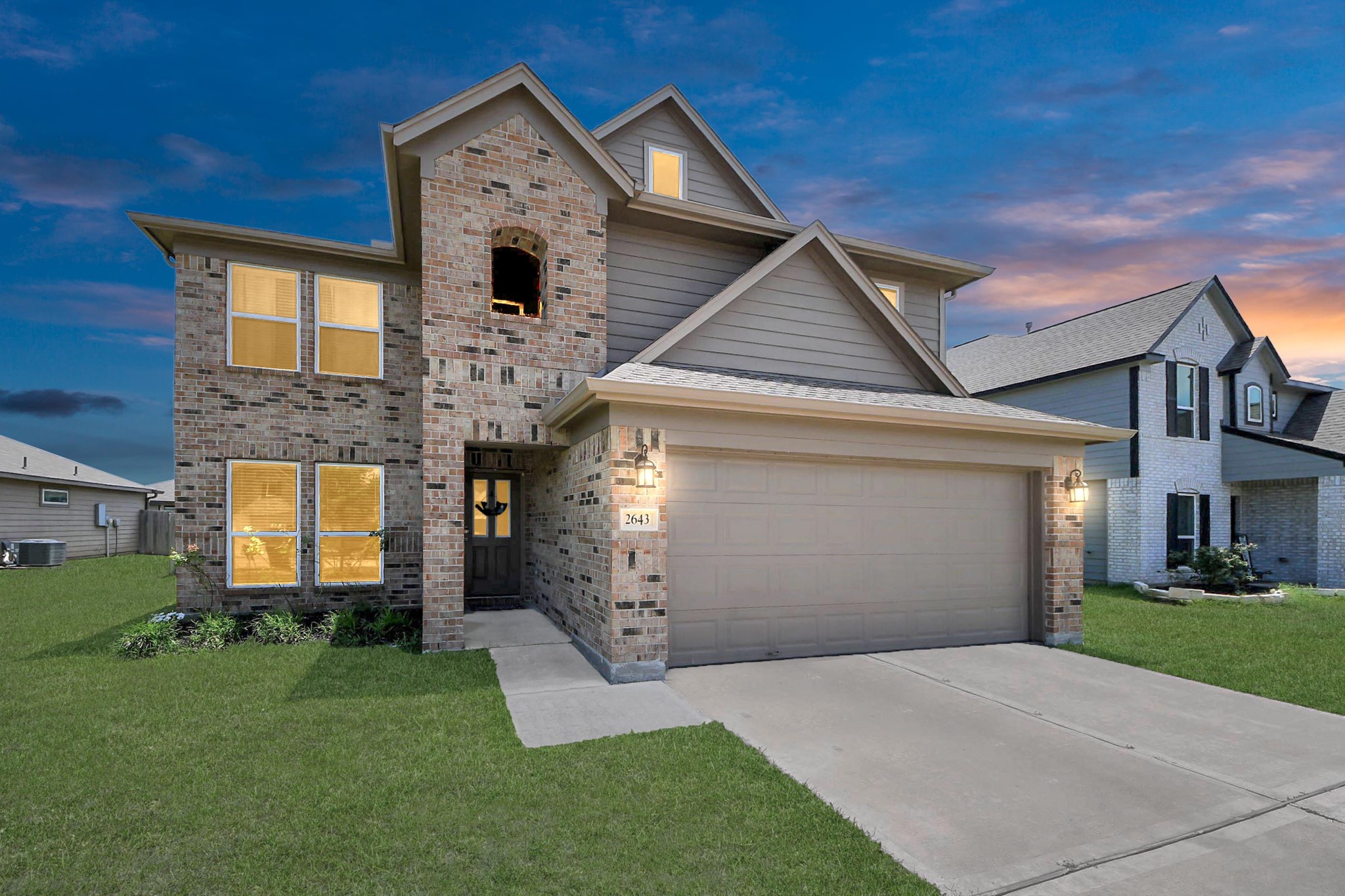 a front view of a house with a yard and garage