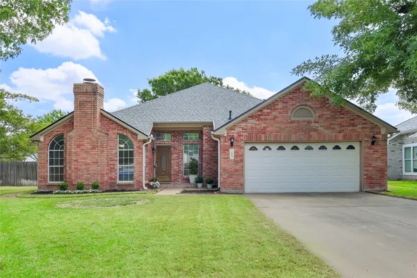 a front view of a house with a garden and yard